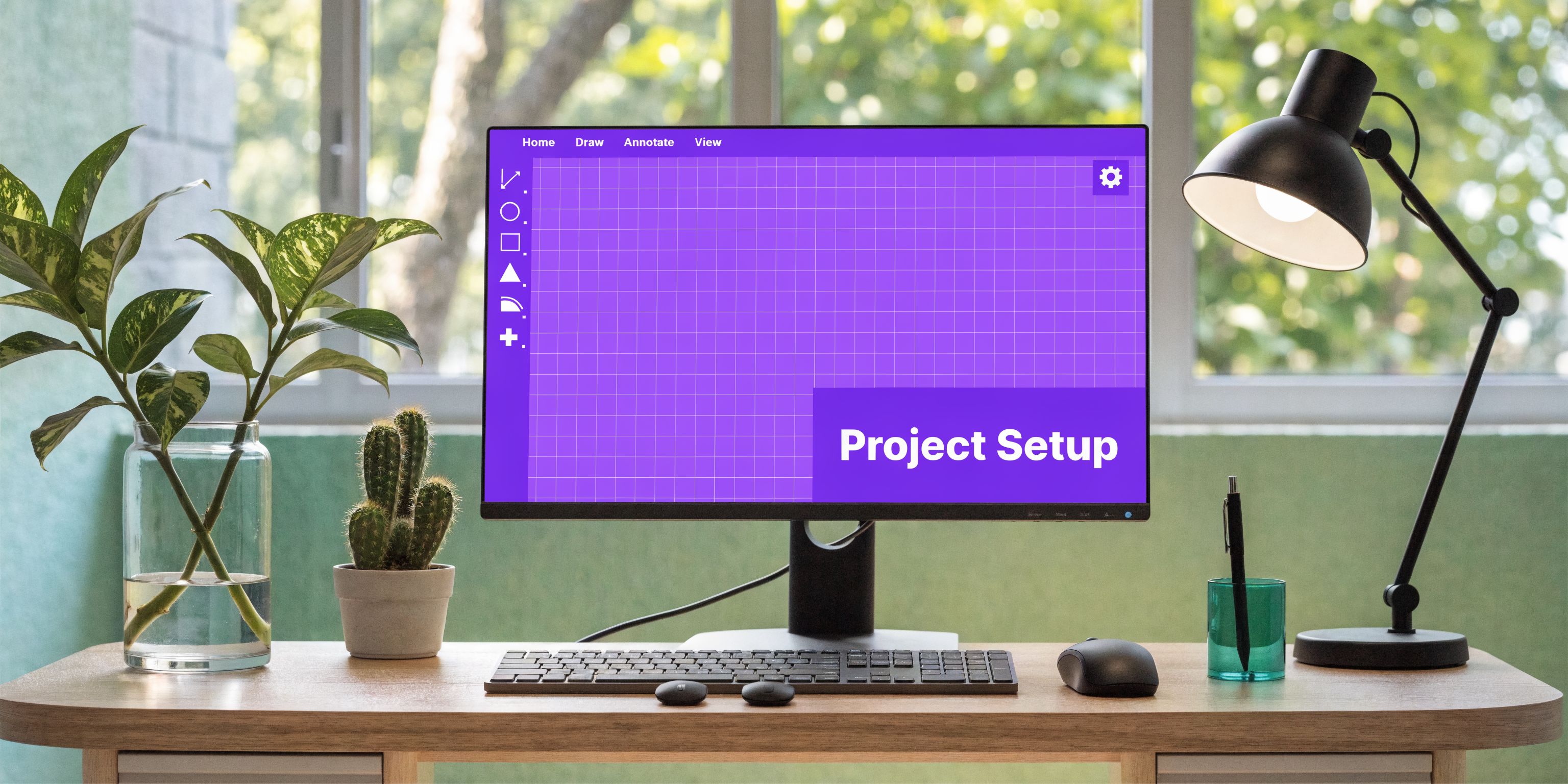 A modern home office desk featuring a computer screen showing AutoCAD room layout project setup software.