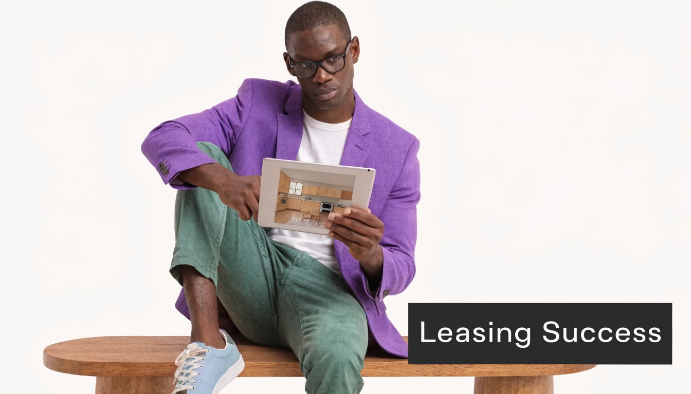 A man in a purple blazer sits on a wooden bench while viewing a kitchen photo on a tablet.